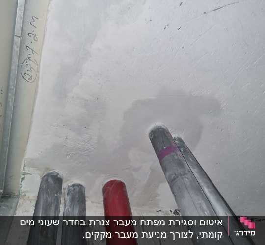 צינורות מתכת בקיר עם טיח לבן